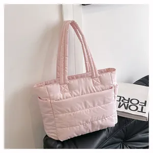 Detail view of pink quilted tote bag showing side storage pockets and puffer texture