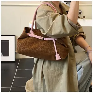 Détail du sac léopard avec bandoulière rose porté par un mannequin en trench-coat