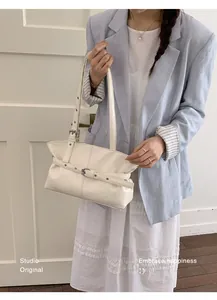 Détail du sac cabas en cuir ciré crème avec sangle à boucle et texture plissée