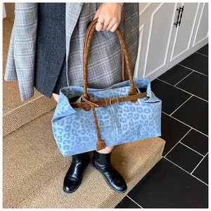 Détail d'un grand sac fourre-tout à imprimé léopard bleu et anses en cuir