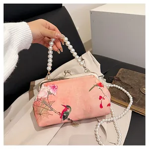 Detail of pink embroidered silk bag with bird patterns and double pearl handles