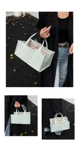 Detail view of light green quilted tote bag with multi-compartment interior for storage