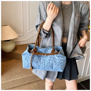 Sac fourre-tout à motif léopard bleu porté avec un blazer à carreaux gris chic