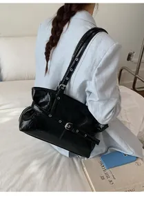 Détail du cabas noir en cuir ciré plissé avec boucles à œillets punk et style rétro Y2K