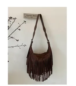 Detail of dark brown suede crossbody bag featuring long fringe and bohemian retro design