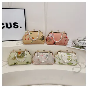 Detail of vintage Chinese silk bags with pearl handles and classic metal kiss-lock closure