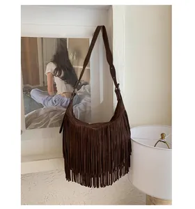 Detailed view of bohemian dark brown suede crossbody bag with long tassel fringe details