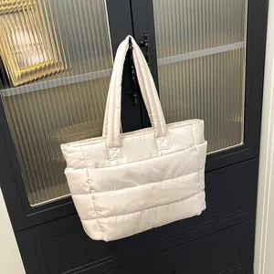 Detail of off-white quilted puffer tote bag with side pocket and fluffy texture