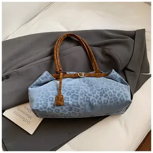 Détail du cabas à imprimé léopard bleu avec anses marron et boucles en métal doré