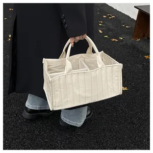 Detailed shot of an off-white quilted tote bag with internal compartments for organizers