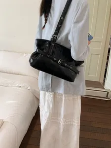Sac fourre-tout noir en cuir ciré avec œillets métalliques et boucles sur la bandoulière