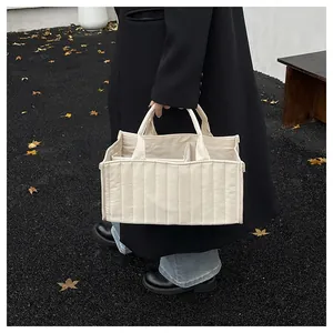 Quilted beige tote bag detail showing internal dividers for organized storage