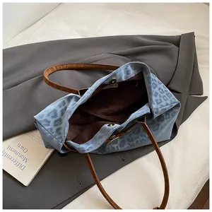 Détail du sac cabas imprimé léopard avec brides en cuir marron et fermoir magnétique