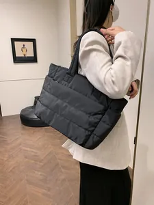 Black quilted tote bag with padded texture and sturdy strap for yoga or travel