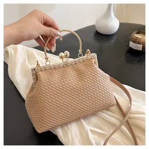 Dettaglio borsa intrecciata marrone chiaro con chiusura a perla e decori in cristallo