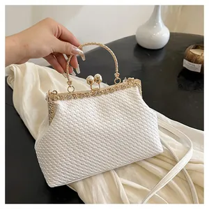 Dettaglio borsa da sera intrecciata bianca con manico ad anello oro e chiusura a perle
