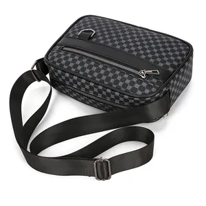 Dettaglio della borsa a tracolla grigio scuro con motivi geometrici e fibbie metalliche