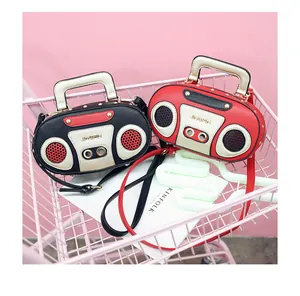 Close-up of retro radio shaped handbag in black and red with top handle and strap hooks