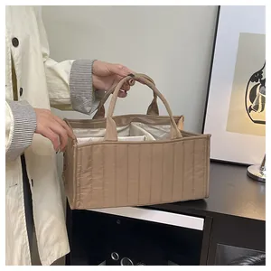 Close-up of khaki quilted nylon tote bag with inner compartments and thick handles