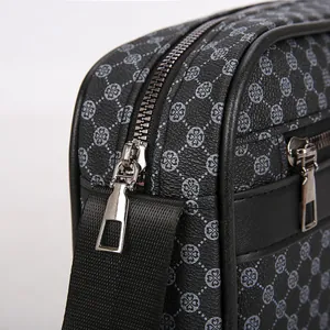 Dettaglio borsa a tracolla da uomo in ecopelle con stampe geometriche e cerniere in metallo