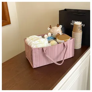 Pink quilted storage tote bag for diapers and baby essentials shown in a home setting
