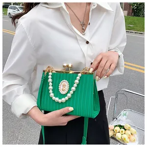 Détail du sac à main rétro vert à rayures avec poignée en perles et décor de camée