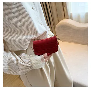 Gros plan d'un porte-cartes rouge à motif crocodile avec fermeture éclair dorée