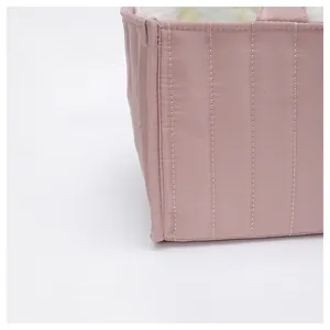 Detail of pink quilted tote bag showing striped stitching and floral print lining