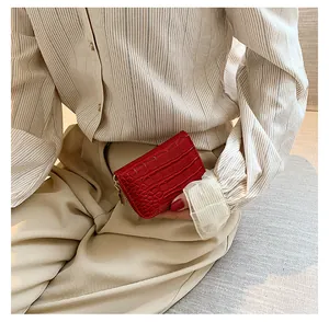 Gros plan du porte-cartes rouge à motif crocodile avec fermeture éclair dorée