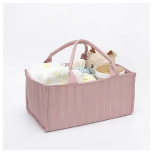 Detailed macro view of pink quilted tote bag storing diapers and soft toys for baby care