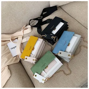 Détail de sacs à bandoulière colorés avec chaînes métalliques et larges sangles en tissu