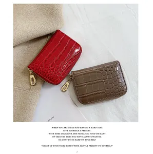 Détail de porte-cartes motif crocodile rouge et marron avec fermetures éclair dorées