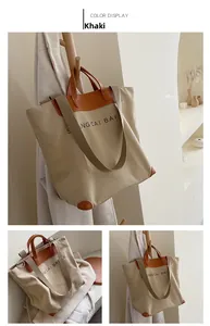 Close-up of khaki canvas tote bag featuring brown leather handles and adjustable shoulder strap