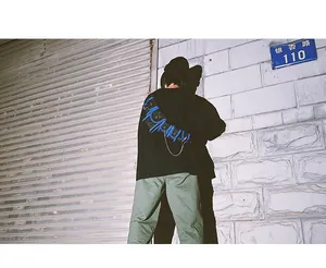 Detail of black tactical crossbody bag with blue ropes and chain on urban background