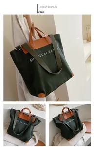 Detail of dark green canvas tote with brown leather corners and wide shoulder strap