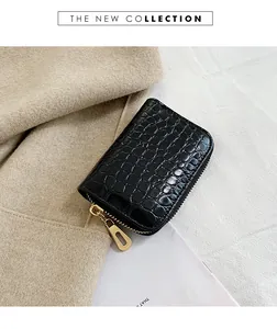 Détail du porte-cartes noir à texture crocodile avec fermeture éclair dorée en forme de U