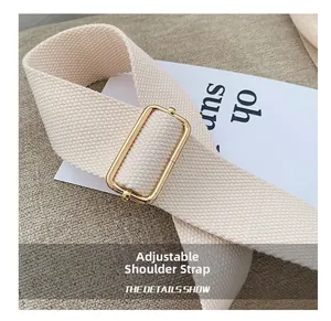 Détail de la bandoulière réglable en tissu beige avec boucle métallique dorée chic