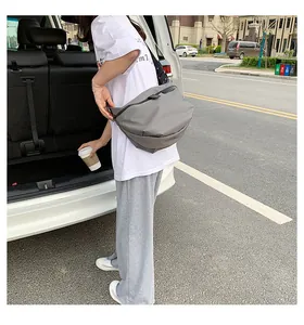 Detail of grey oxford fabric crossbody bag with adjustable strap and waterproof matte finish