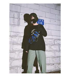 Street style view of mini crossbody tactical bag with metal chain on black sweatshirt