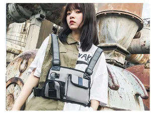 Close-up of industrial techwear chest rig featuring reflective straps and buckle details
