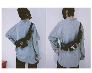 Detail view of black techwear chest bag featuring metal chains and multi-pocket design