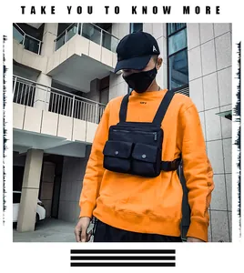 Détail d'un sac de poitrine tactique noir avec deux poches à pression sur un sweatshirt