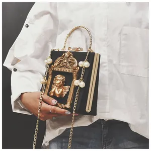Detail of vintage box bag featuring golden angel relief and pearl chain strap