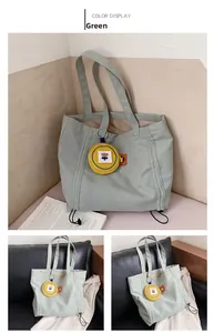 Detail of green canvas tote bag with a yellow flower coin purse and black drawstrings