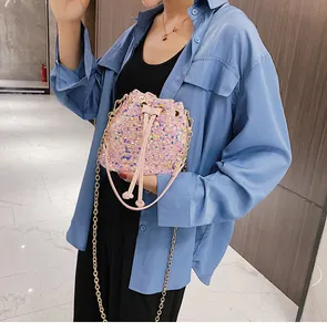 Close-up of pink iridescent sequin bucket bag with golden chain and drawstring detail