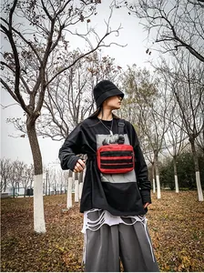 Close-up of a red streetwear crossbody bag with FASHION logo and black adjustable strap