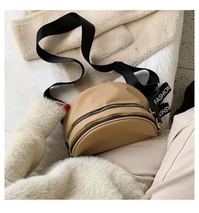 Detail view of khaki crescent waist bag with double zippers and fashion strap
