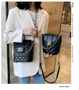 Detail of black quilted bucket bag featuring gold ring buckle and chain shoulder strap