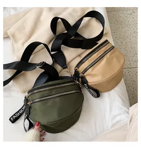Detail view of nylon crossbody waist bags in army green and khaki with double zippers