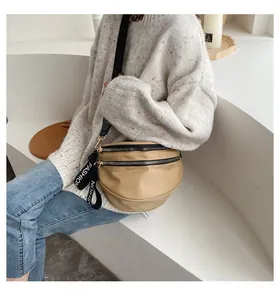 Detail of khaki nylon half-moon waist bag with dual zippers and golden hardware